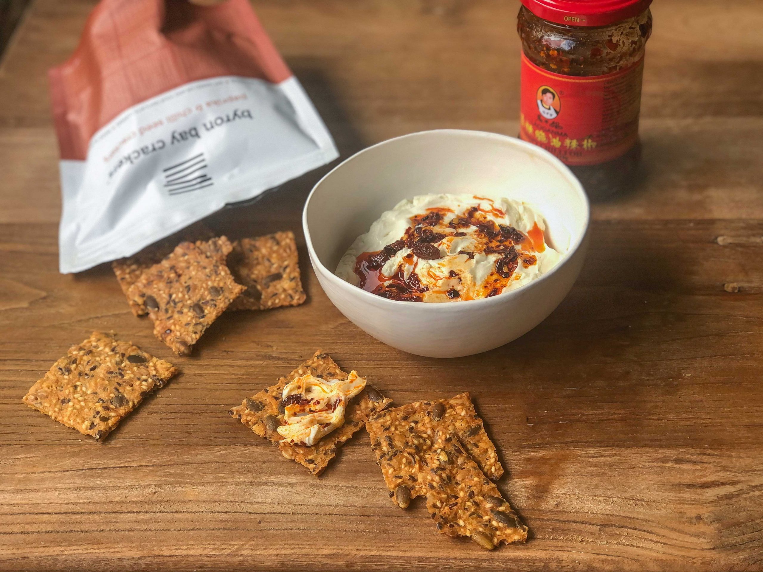 Labneh with crispy chilli oil in white bowl served with Byron Bay Crackers