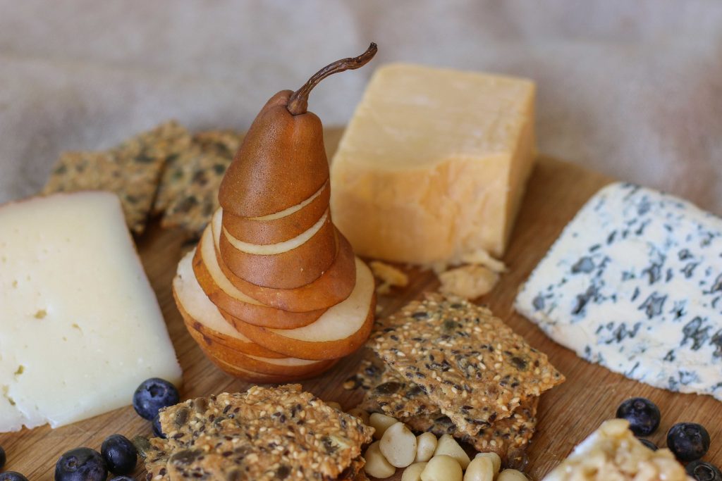 Sliced fruit and crackers on cheeseboard